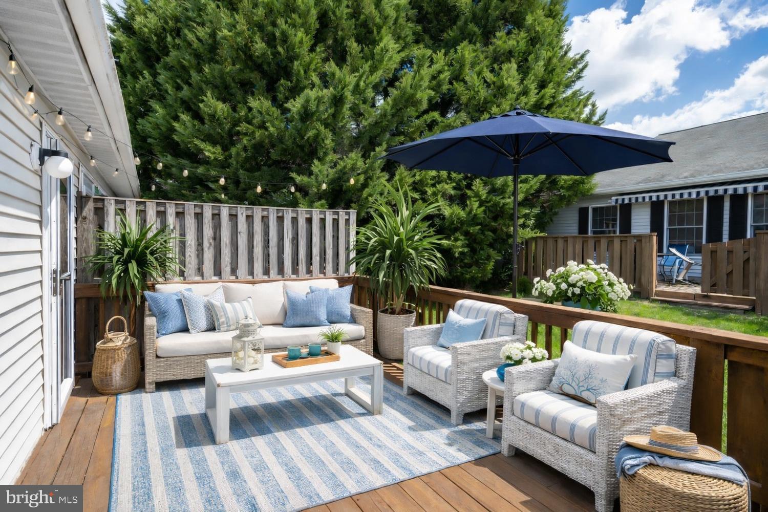 2627 Compass Drive Annapolis, MD 21401 - Photo 15 of 37 a view of a patio with couches table and chairs under an umbrella with wooden floor