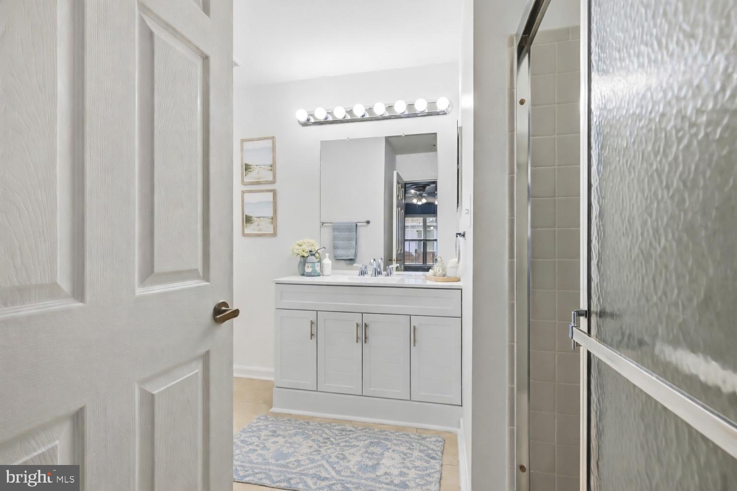 2627 Compass Drive Annapolis, MD 21401 - Photo 23 of 37 a bathroom with a sink a mirror and a shower