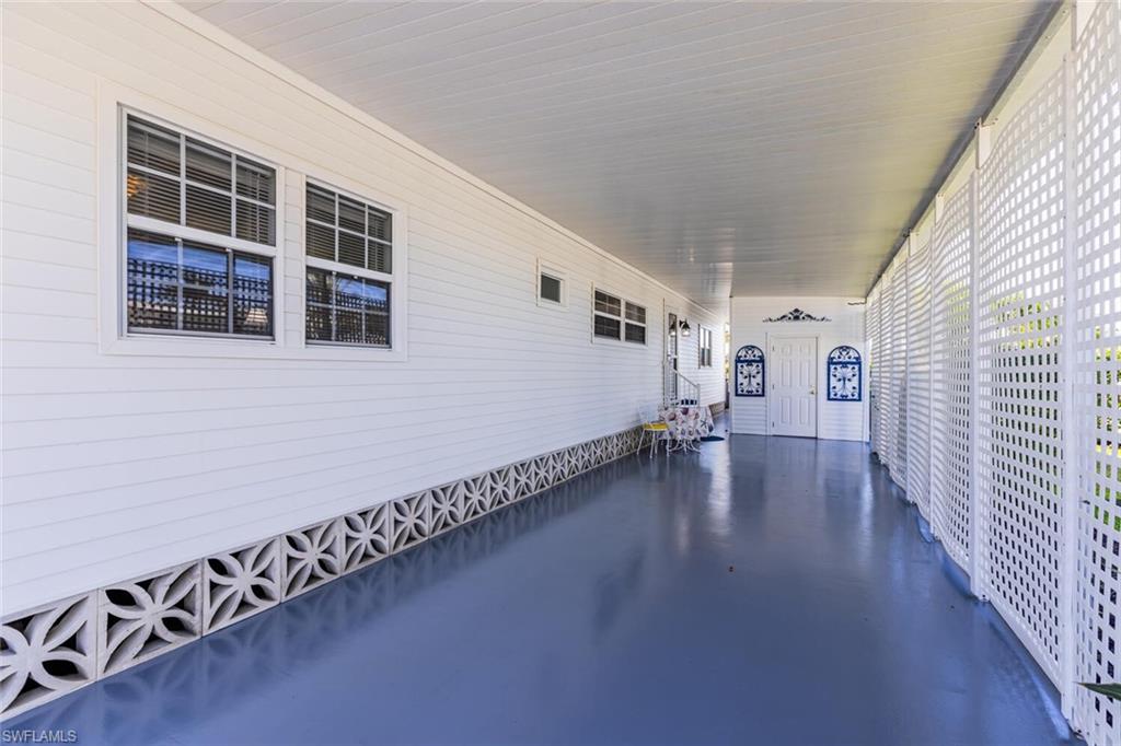 103 Audubon Road Naples, FL 34114 - Photo 3 of 7 a view of a porch with wooden floor and windows