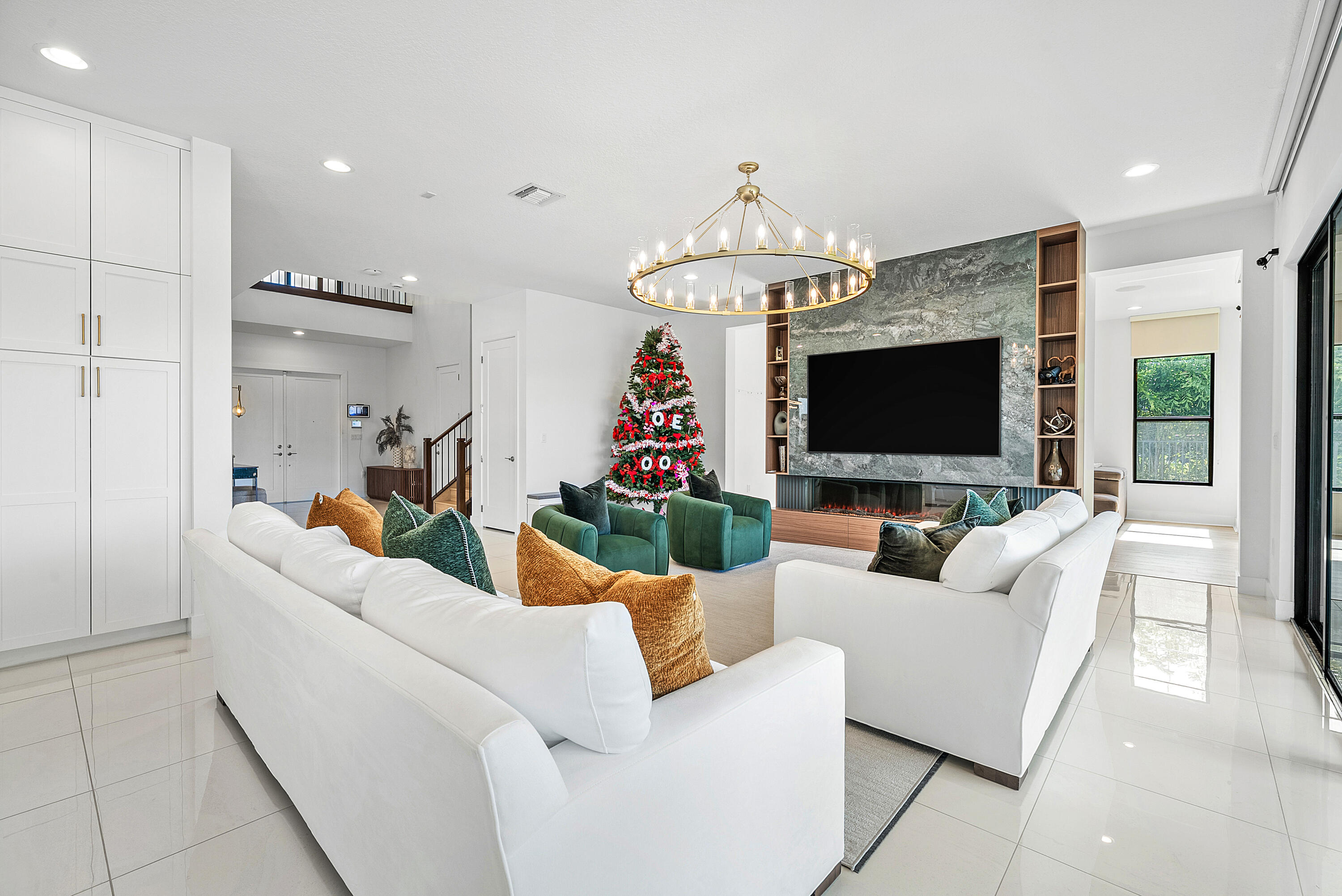 20145 Castle Stuart Avenue Boca Raton, FL 33434 - Photo 14 of 95 a living room with furniture a flat screen tv and a chandelier