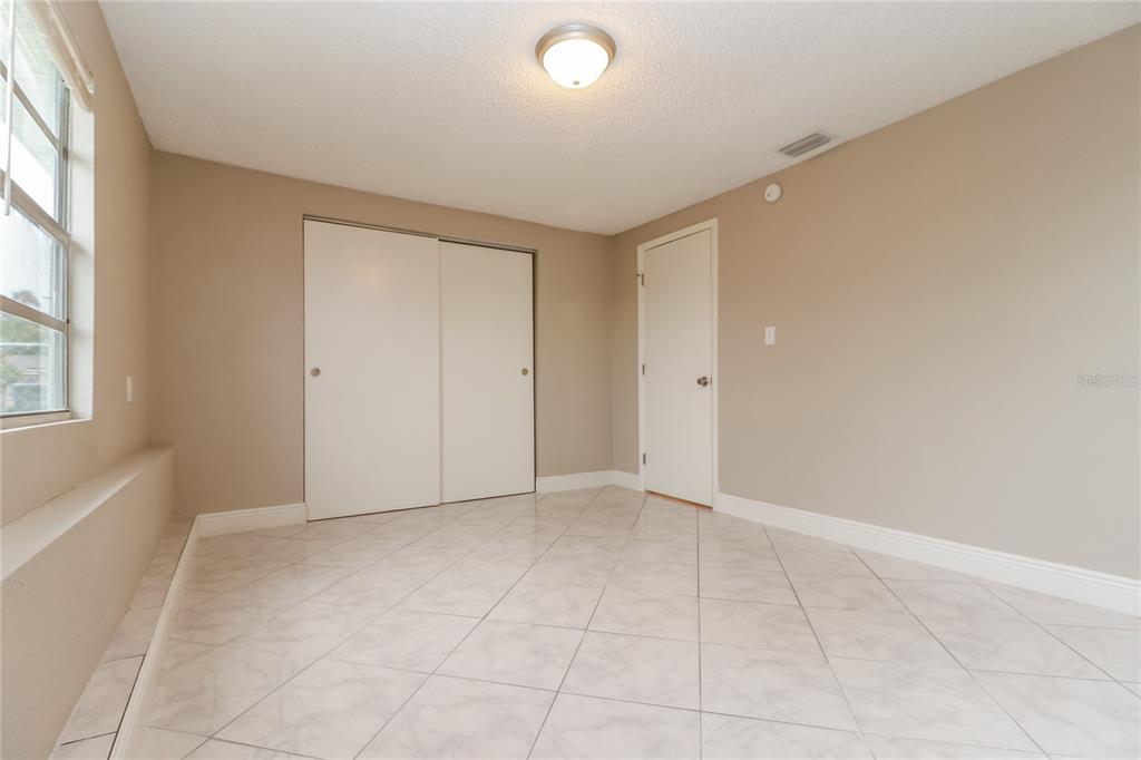 9226 Rainbow Lane Port Richey, FL 34668 - Photo 12 of 16 an empty room with windows and closet