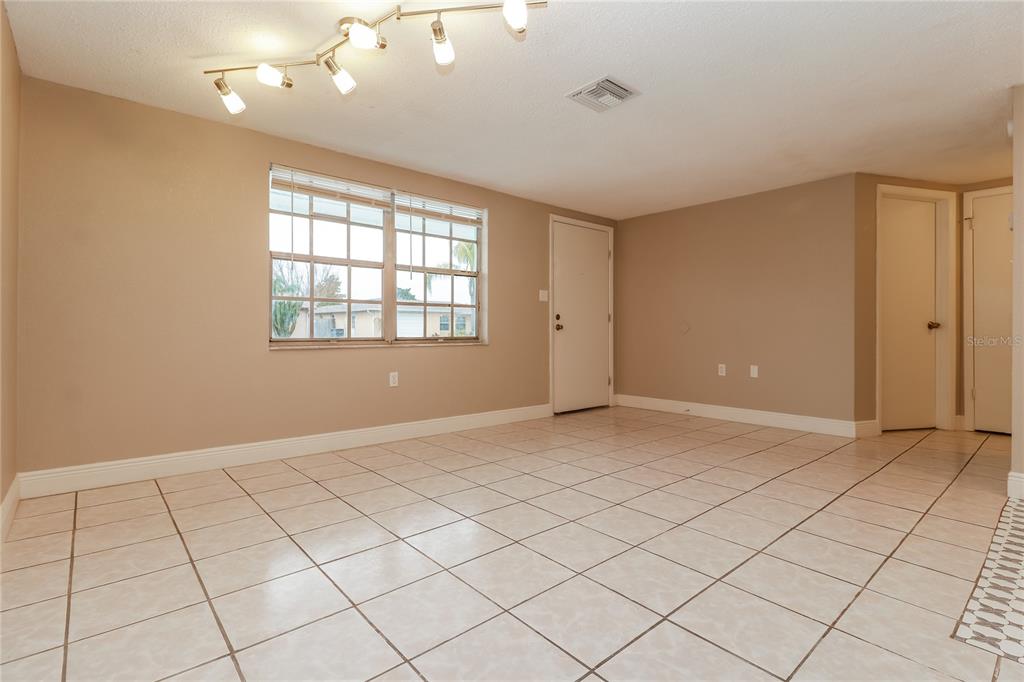 9226 Rainbow Lane Port Richey, FL 34668 - Photo 2 of 16 an empty room with windows and fan
