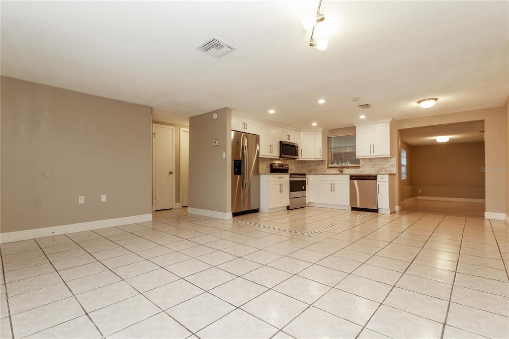 9226 Rainbow Lane Port Richey, FL 34668 - Photo 3 of 16 a view of kitchen with stainless steel appliances granite countertop a refrigerator and a stove top oven