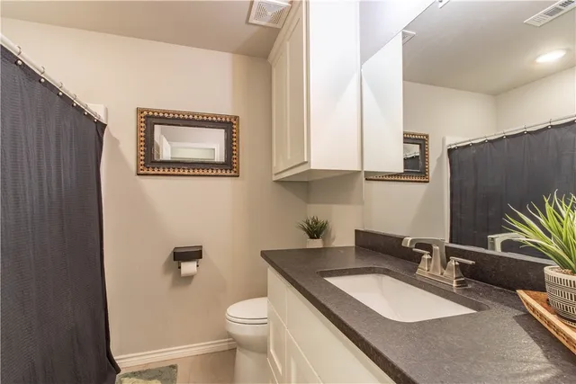 a living room with furniture a flat screen tv and kitchen view