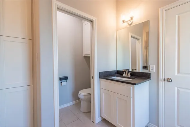 a bathroom with a granite countertop sink toilet and a mirror