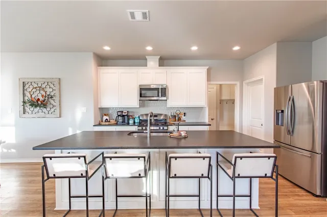 a kitchen with a sink microwave and cabinets