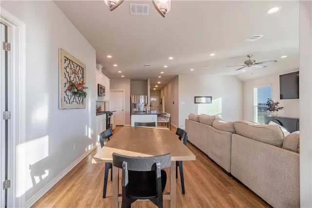 a view of a dining room with furniture a chandelier and wooden floor