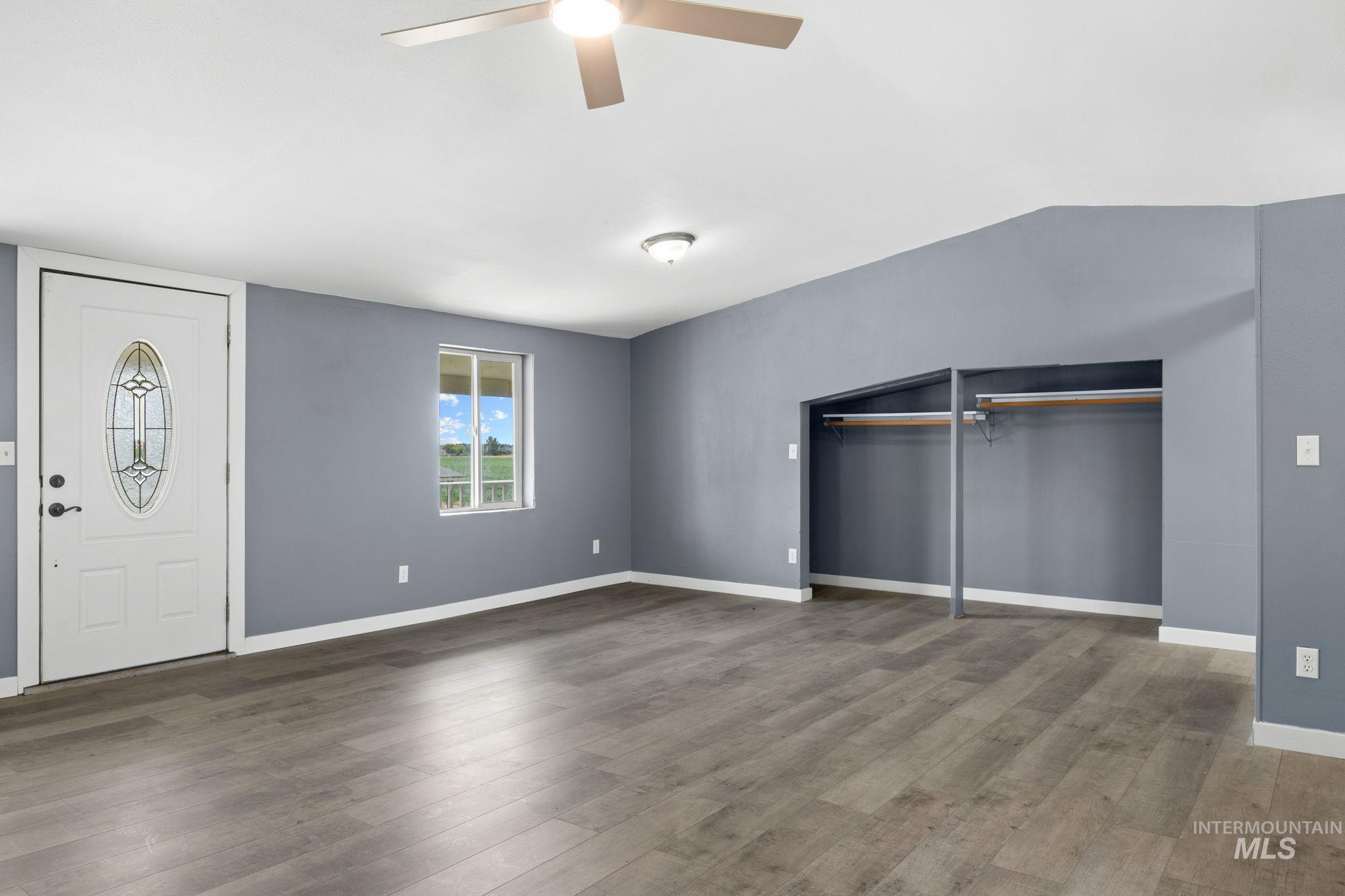 18338 Pride Lane Caldwell, ID 83607 - Photo 36 of 50 Spacious room featuring wood-finish flooring, a white entry door with decorative glass, and a window offering abundant natural light
