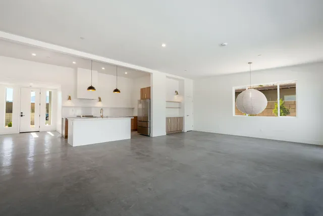 an empty room with a ceiling fan and next to a window