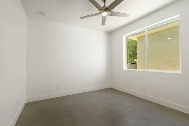a view of an empty room with window and a kitchen