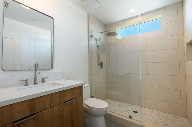 a bathroom with a sink a toilet and shower