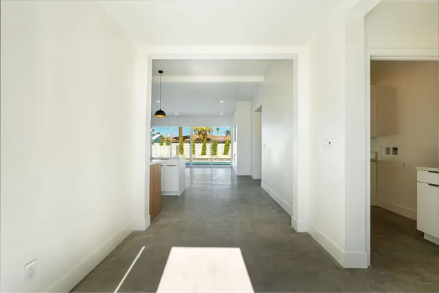 a kitchen with stainless steel appliances granite countertop a refrigerator a oven a sink and a dining table with wooden floor