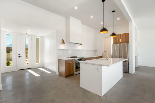 a kitchen with stainless steel appliances granite countertop a sink a stove and a refrigerator