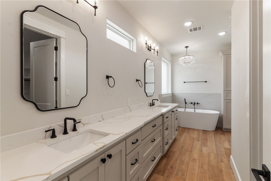 7822 Mathis Crk Drive Bryan, TX 77808 - Photo 20 of 43 a bathroom with double vanity sinks double vanity tub and a mirror
