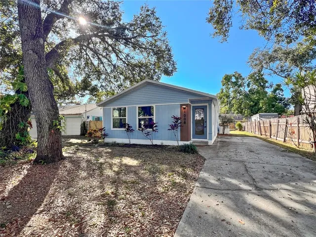 a view of a house with backyard and a tree