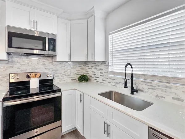 a kitchen with a sink stove and microwave