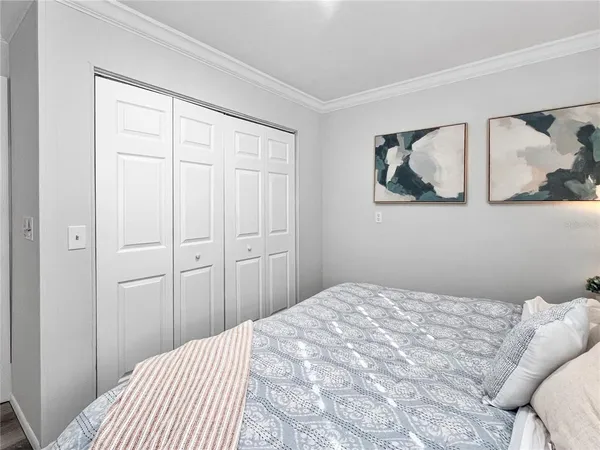a bedroom with a bed and painting on the wall