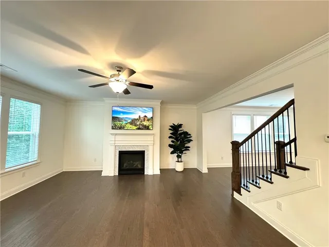 wooden floor in an empty room with a fireplace and a window