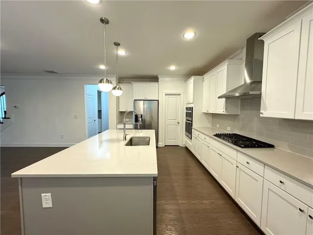 a kitchen with white cabinets and appliances