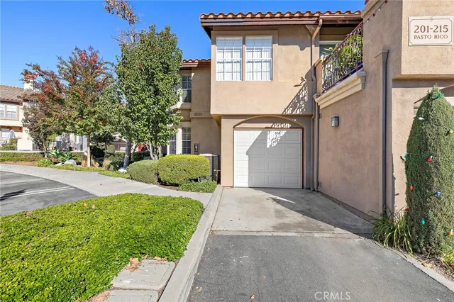 a view of a house with a yard and large trees