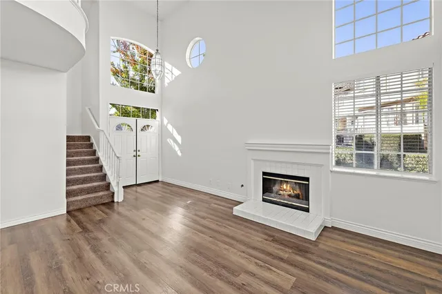 a view of a livingroom with wooden floor and a fireplace