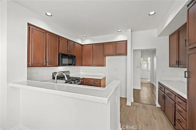 a kitchen that has a sink a stove and cabinets