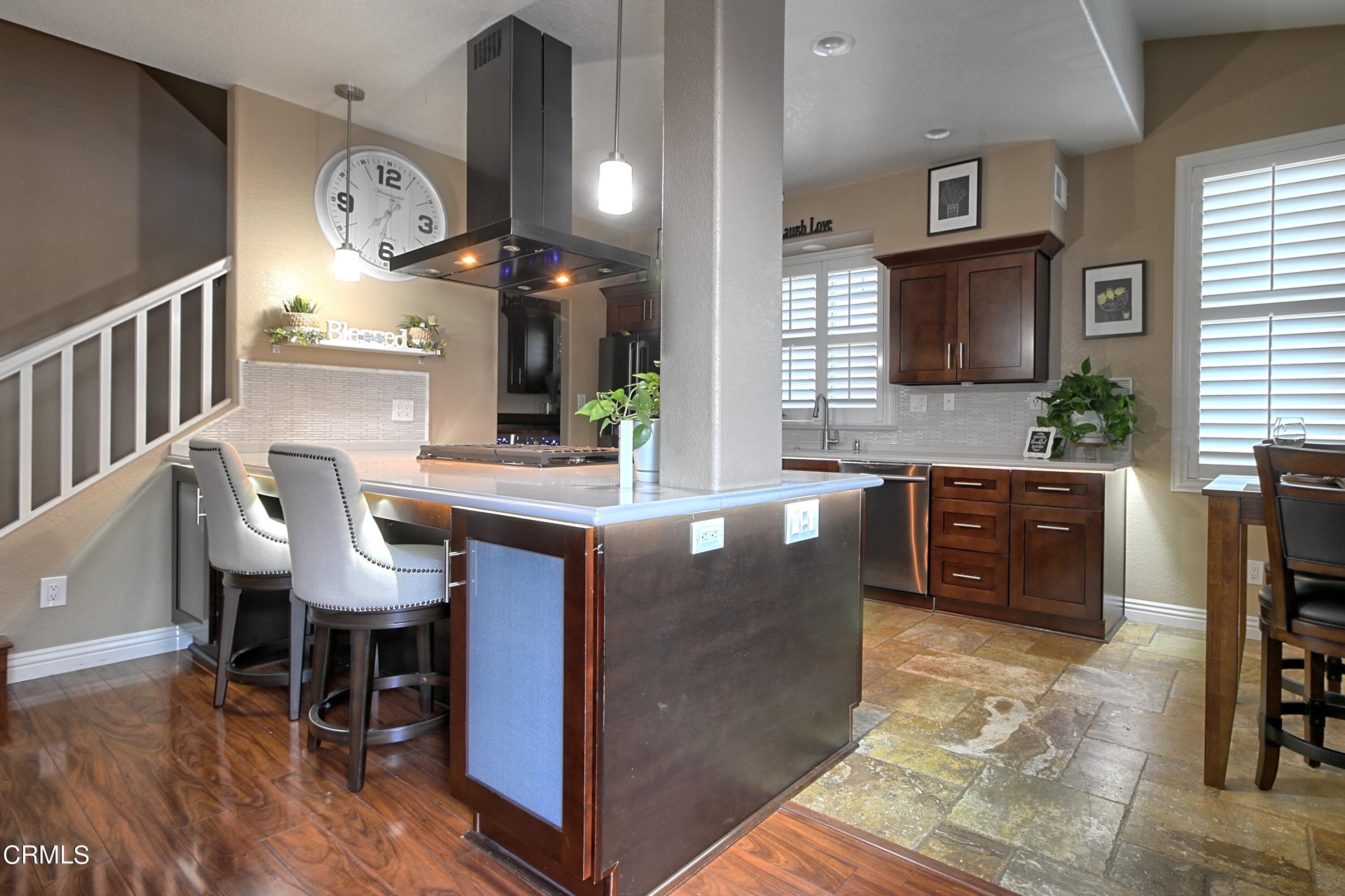 2062 Avila Place Oxnard, CA 93036 - Photo 12 of 52 a living room with couches a flat tv screen and a dining table with wooden floor