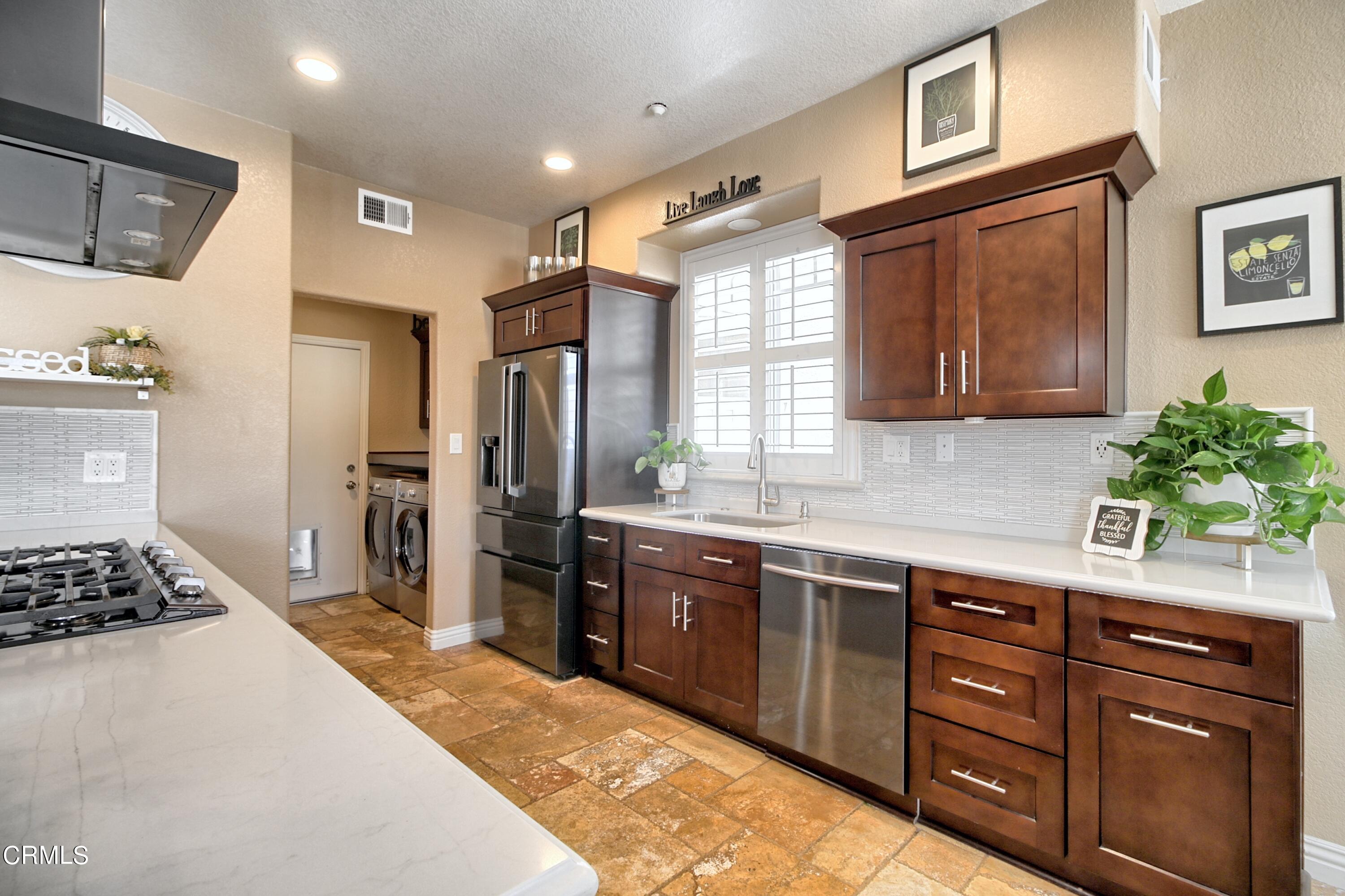 2062 Avila Place Oxnard, CA 93036 - Photo 13 of 52 a large kitchen with stainless steel appliances granite countertop a stove a sink dishwasher and a refrigerator with wooden cabinets
