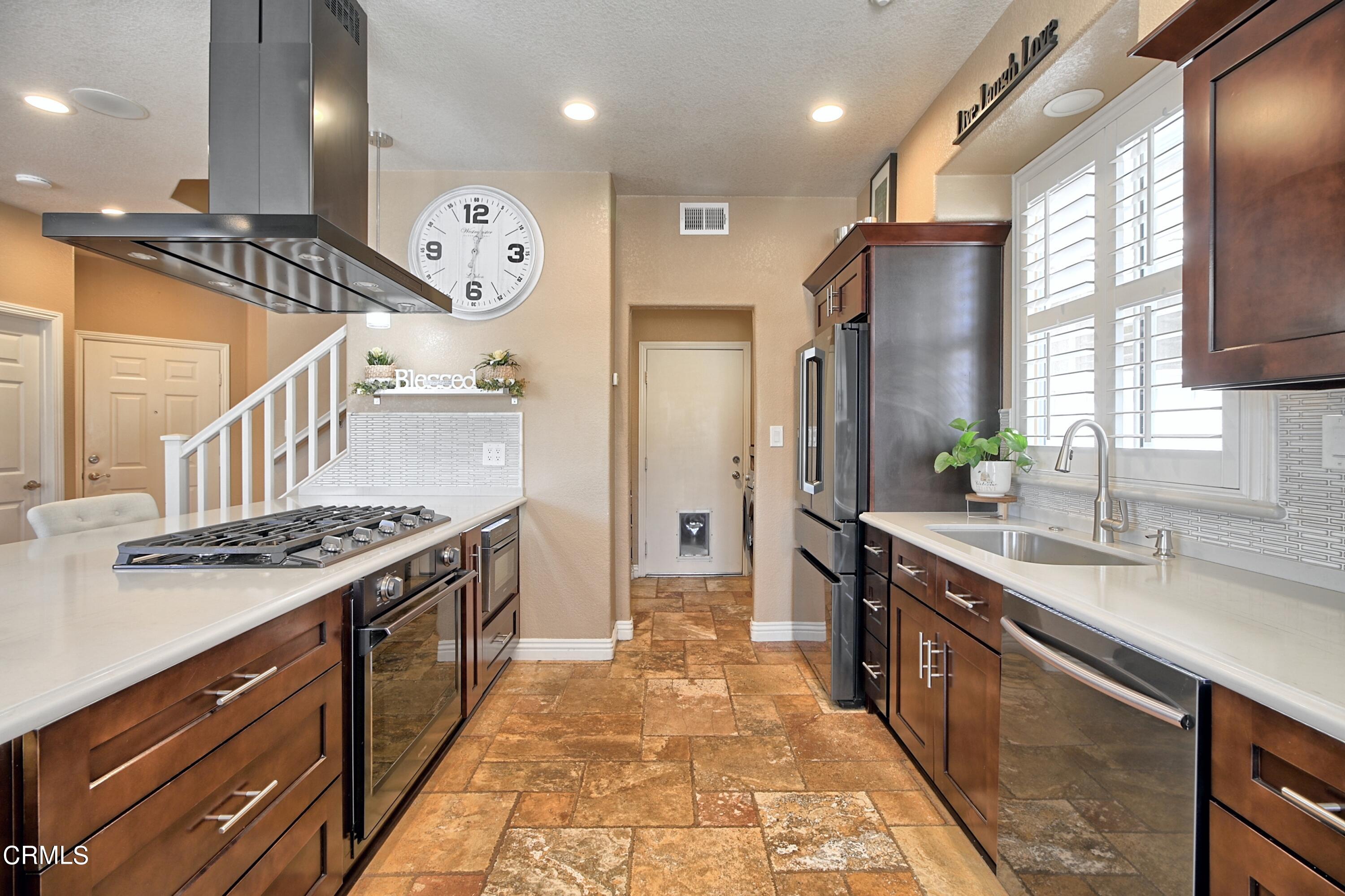 2062 Avila Place Oxnard, CA 93036 - Photo 14 of 52 a large kitchen with stainless steel appliances granite countertop a stove a sink and a refrigerator
