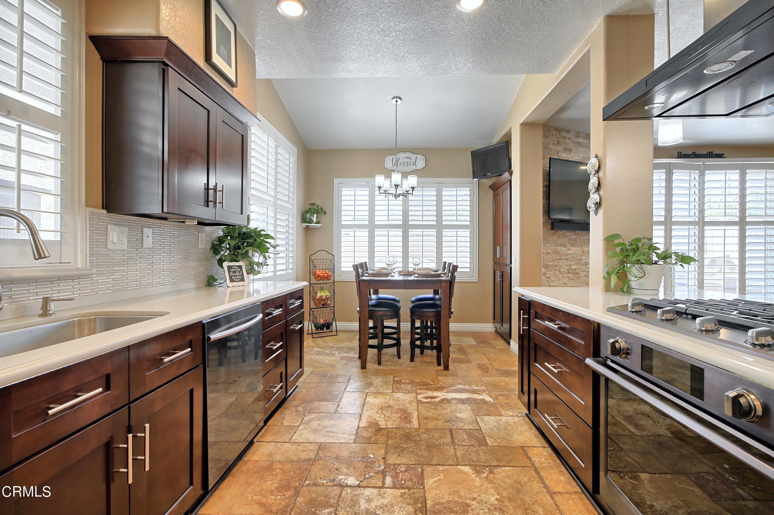 2062 Avila Place Oxnard, CA 93036 - Photo 15 of 52 a kitchen with kitchen island granite countertop a sink stainless steel appliances dining table and chairs