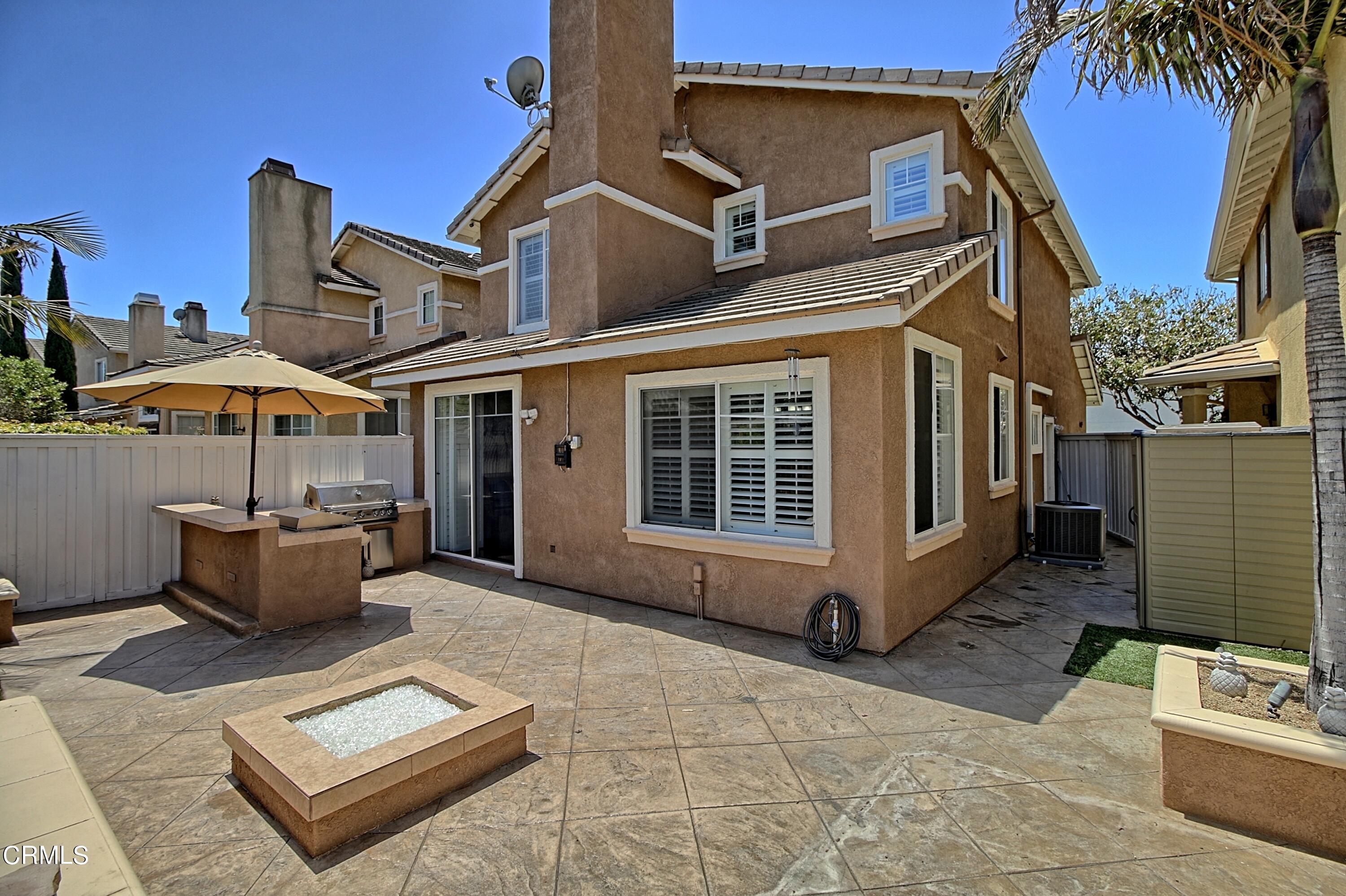 2062 Avila Place Oxnard, CA 93036 - Photo 27 of 52 a view of a patio with couches table and chairs under an umbrella