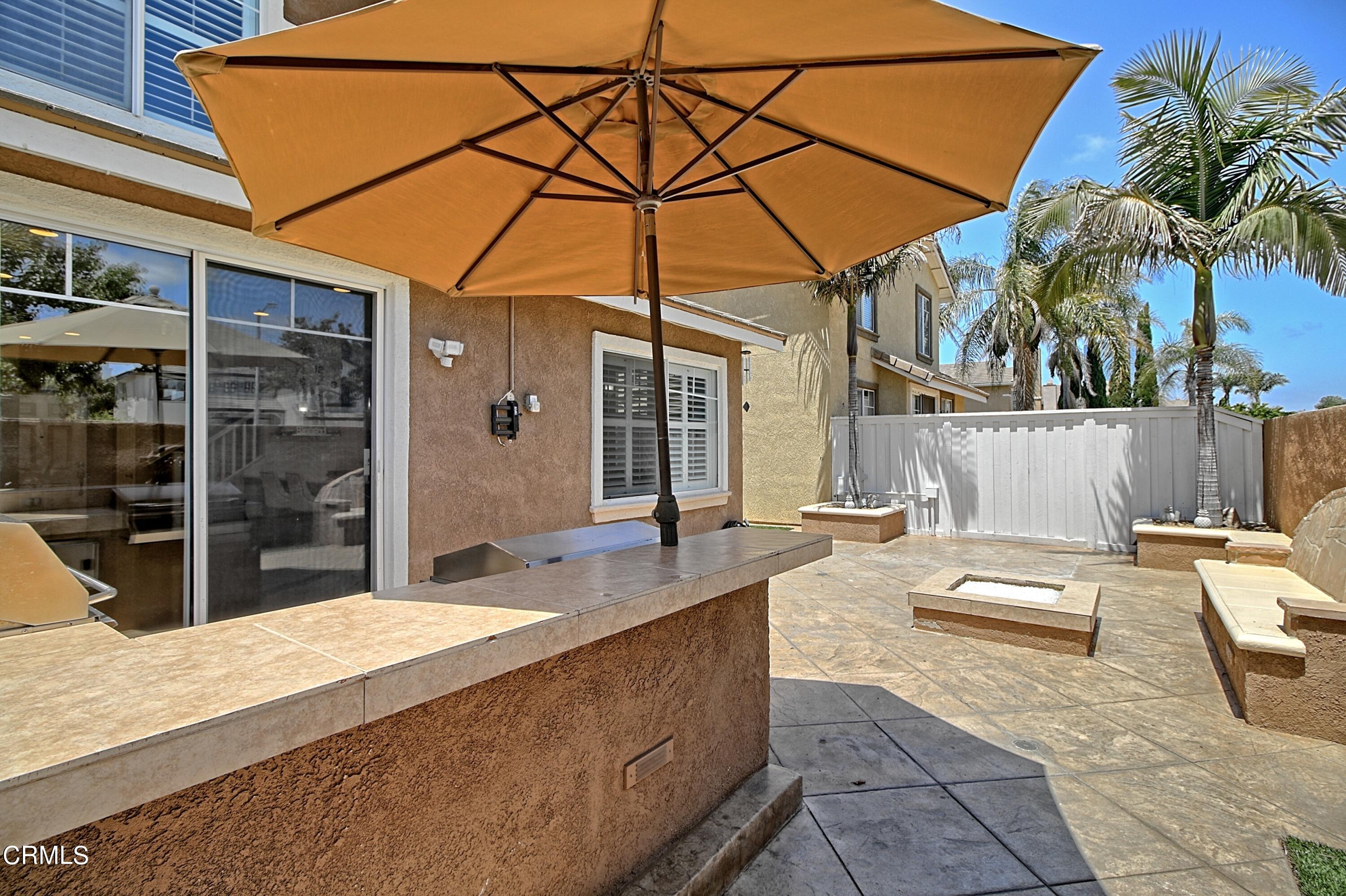 2062 Avila Place Oxnard, CA 93036 - Photo 41 of 52 a patio with a table and chairs under an umbrella
