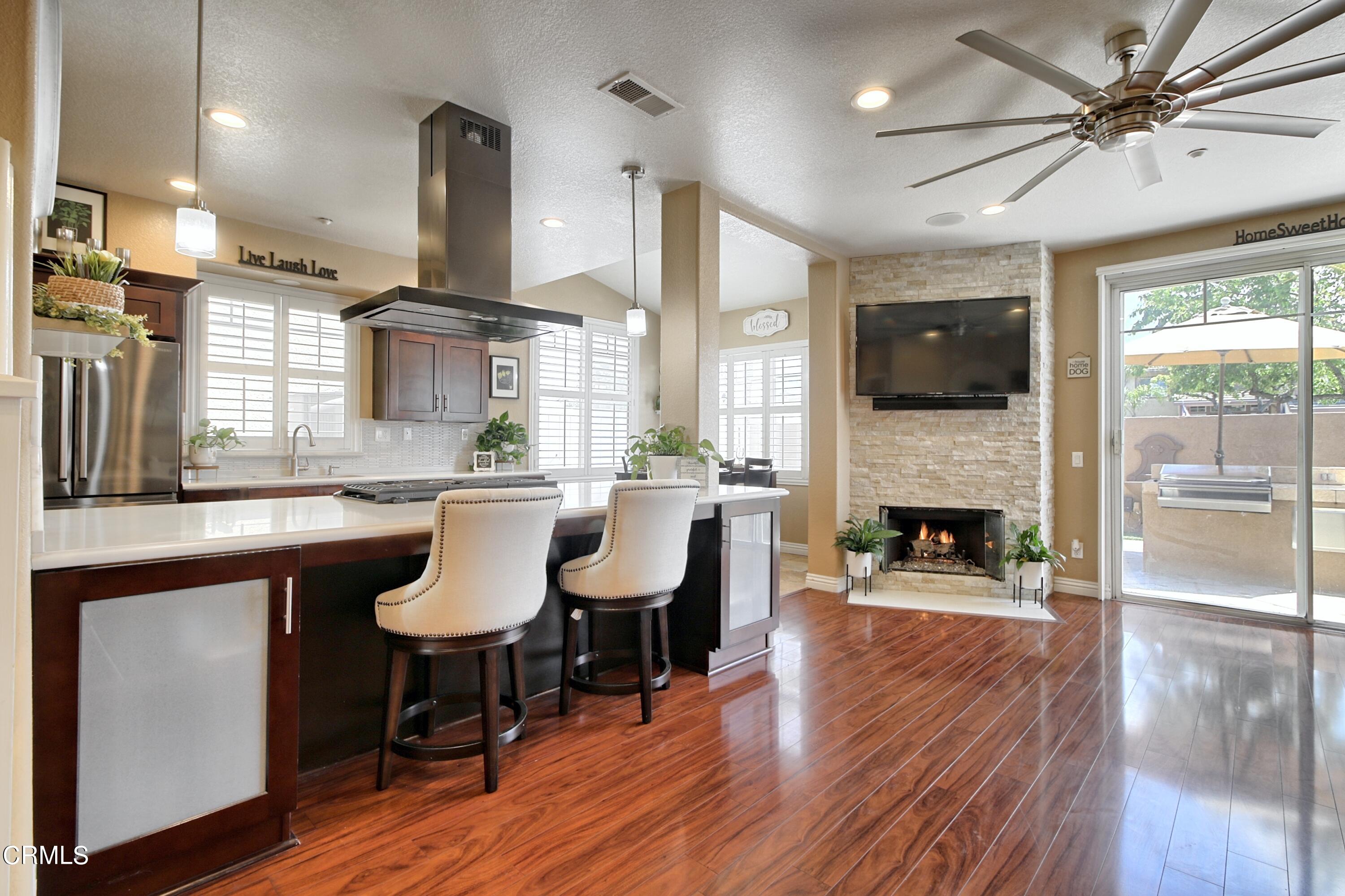 2062 Avila Place Oxnard, CA 93036 - Photo 6 of 52 a dining hall with a dining table chairs with fireplace and wooden floor