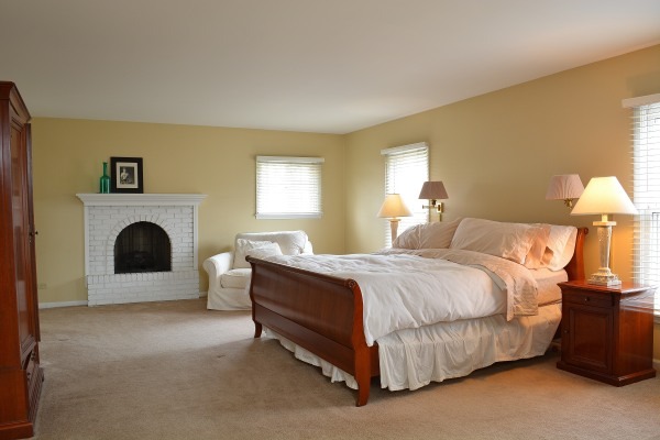 1833 Clover Road Northbrook, IL 60062 - Photo 17 of 25 a spacious bedroom with a bed and a fireplace