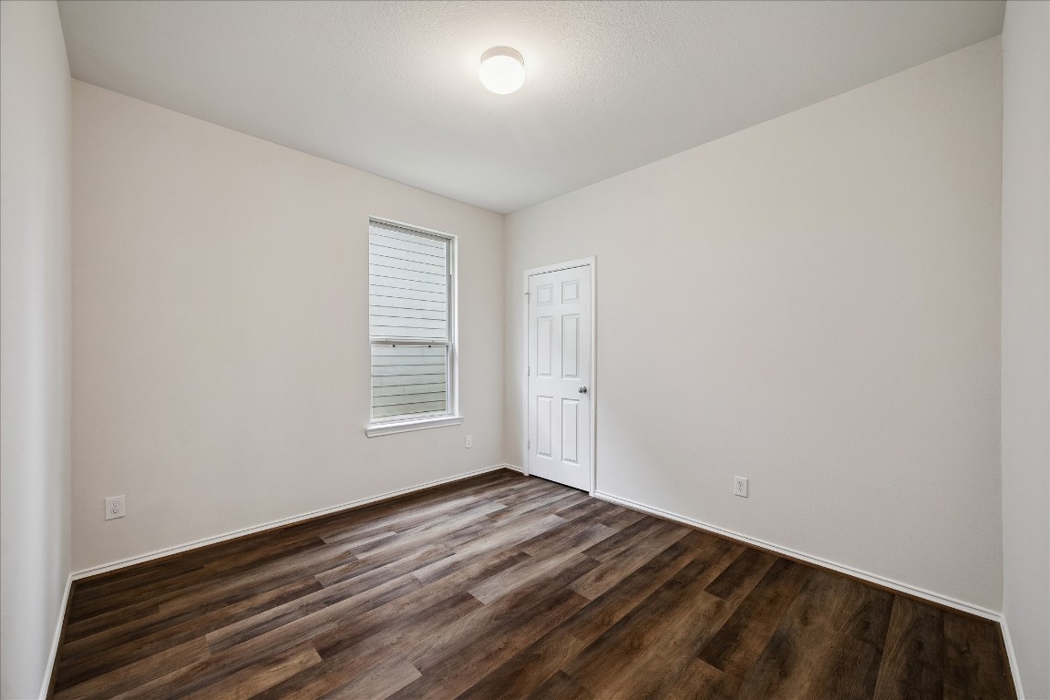 4275 Pine Still Road Conroe, TX 77304 - Photo 15 of 20 a view of an empty room with wooden floor and a window