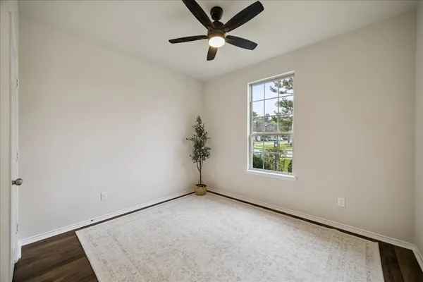 an empty room with a window and a fan