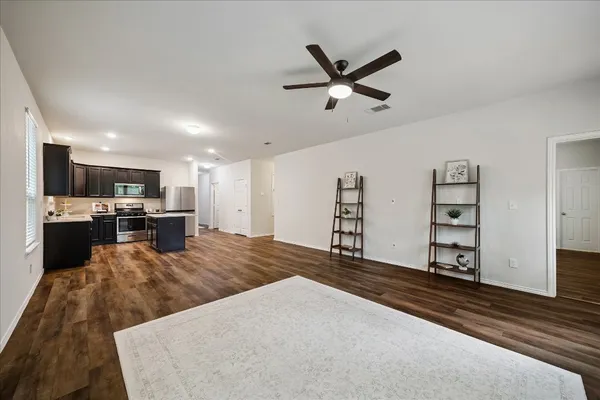a living room with stainless steel appliances kitchen island furniture and a view of kitchen