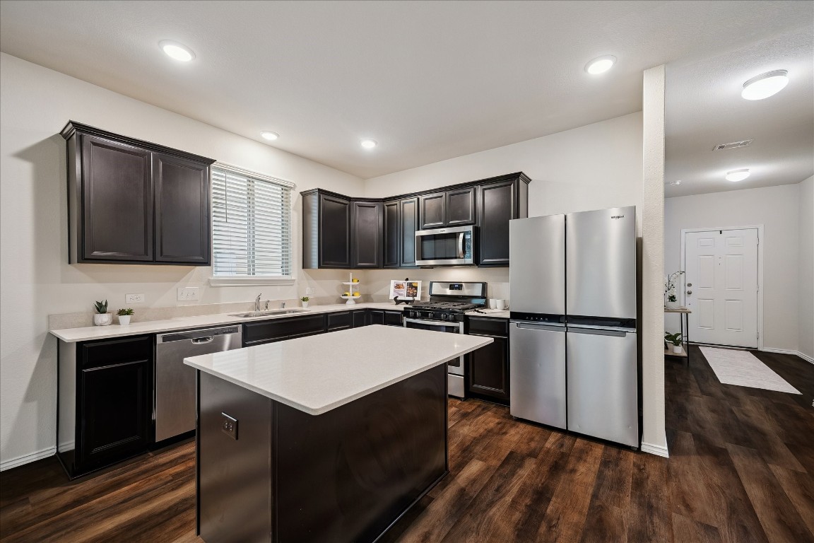 4275 Pine Still Road Conroe, TX 77304 - Photo 9 of 20 a kitchen with a refrigerator a sink and wooden cabinets