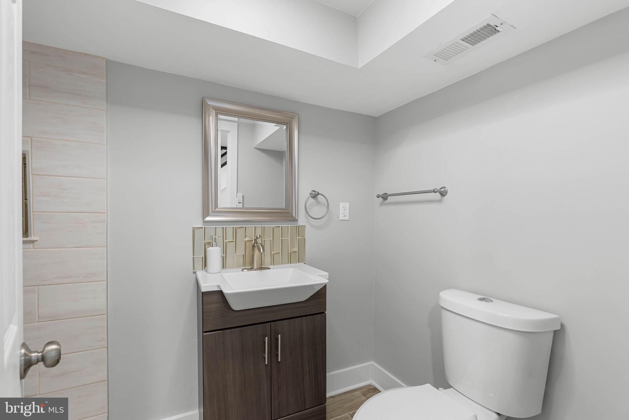 2639 Ellsworth Street Philadelphia, PA 19146 - Photo 19 of 20 a bathroom with a toilet a sink and mirror