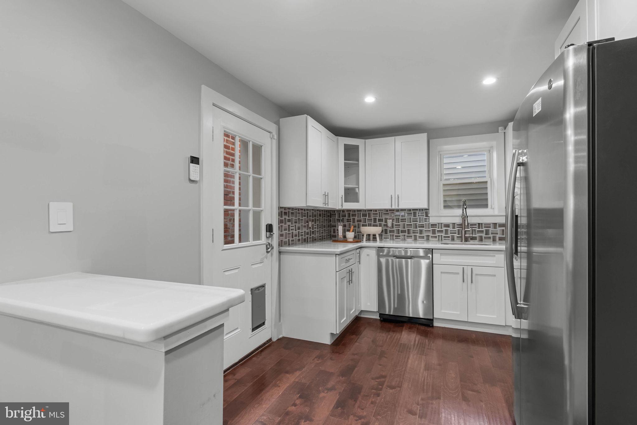 2639 Ellsworth Street Philadelphia, PA 19146 - Photo 5 of 20 a kitchen with granite countertop white cabinets and white appliances