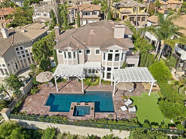 an aerial view of residential houses with outdoor space and parking
