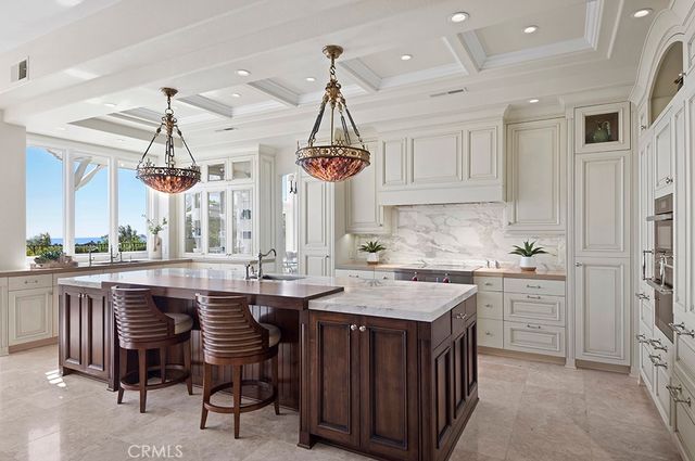 a kitchen with a sink a counter space appliances and cabinets