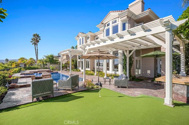 a view of a house with a backyard patio and swimming pool
