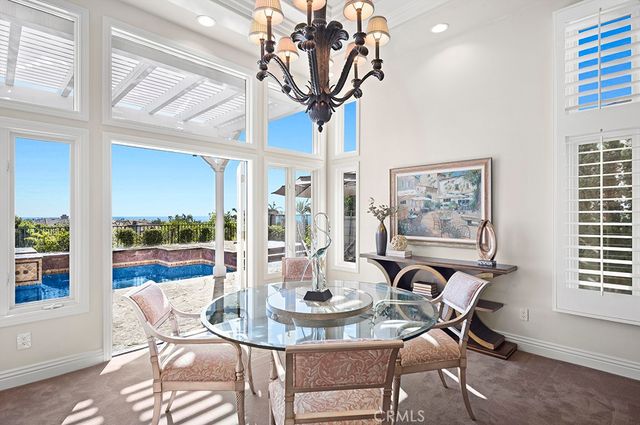 a view of a dining room with furniture a chandelier and wooden floor