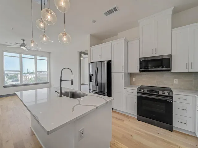 a kitchen with kitchen island a stove and a sink