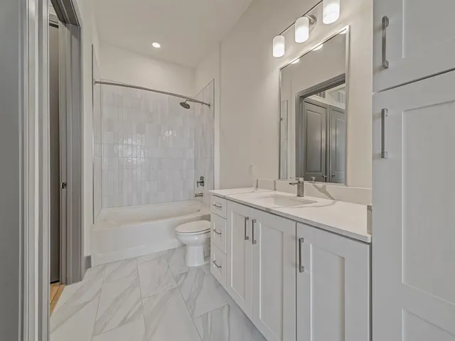 a bathroom with a sink a toilet a mirror and shower