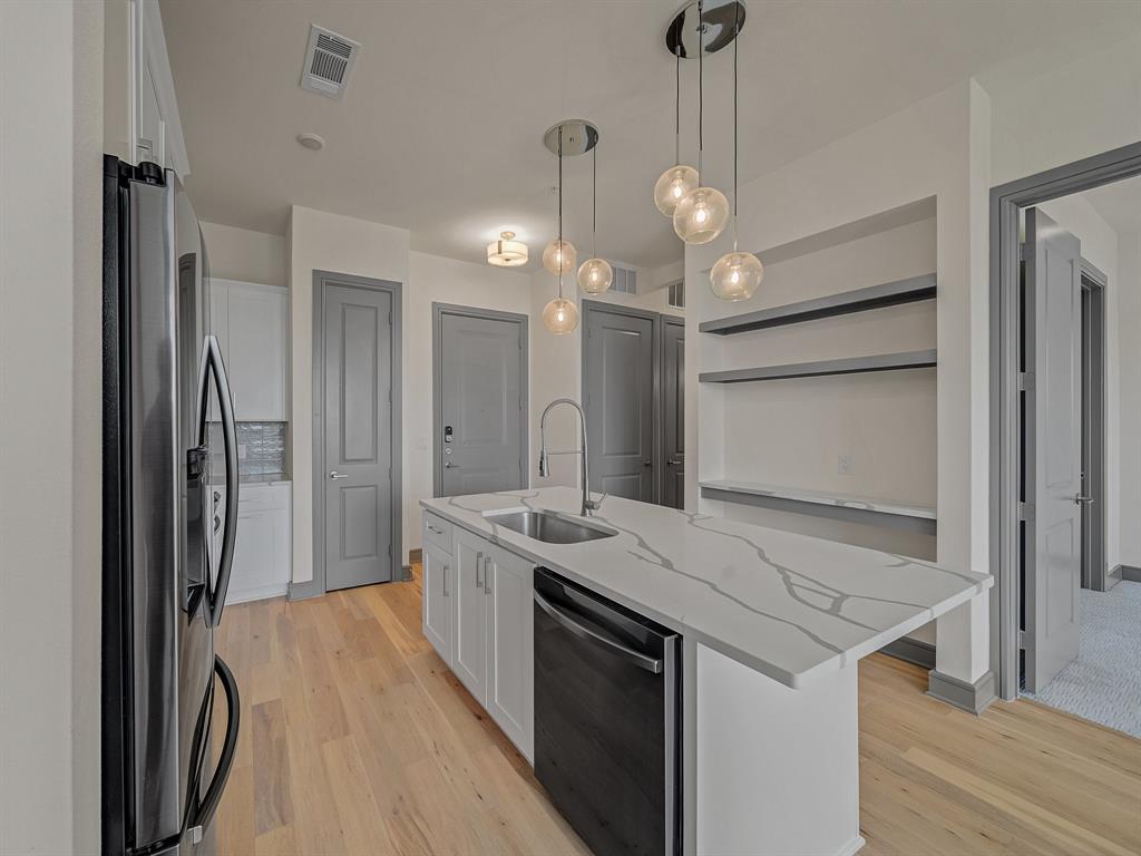 2700 Old Denton Road, Unit 3347 Carrollton, TX 75007 - Photo 4 of 30 a view of a kitchen island a sink stainless steel appliances and cabinets