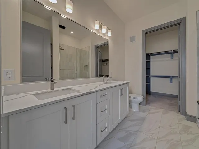 a spacious bathroom with a granite countertop sink and a mirror