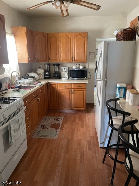 a kitchen with a table chairs a refrigerator and cabinets