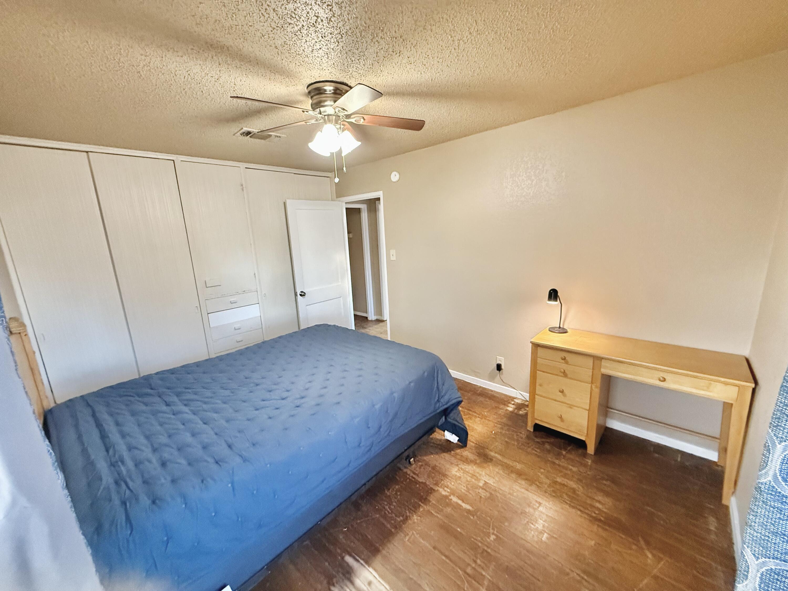 3602 31st Street Lubbock, TX 79410 - Photo 26 of 33 a bedroom with a bed and a chandelier